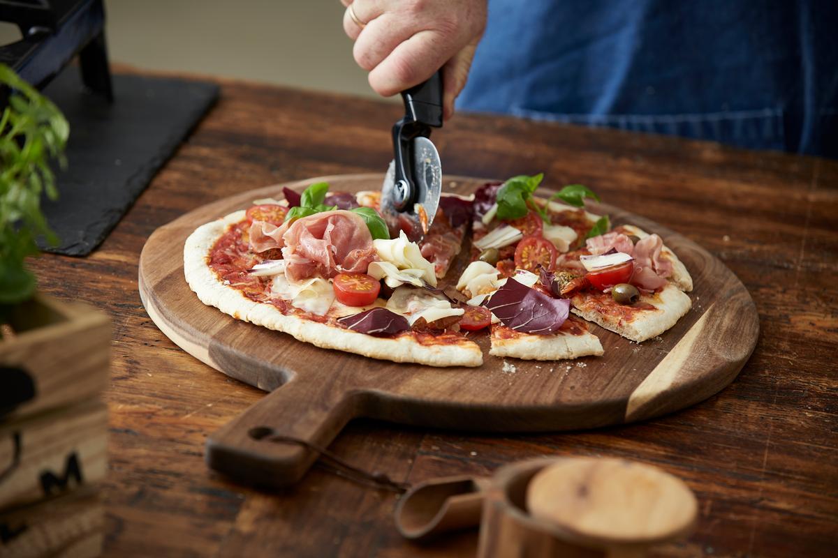 Ta pizzaen rett ut av ovnen og du kan både skjære og servere maten på en og samme fjøl.